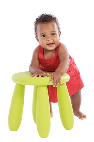 Toddler playing with a chair a over white background